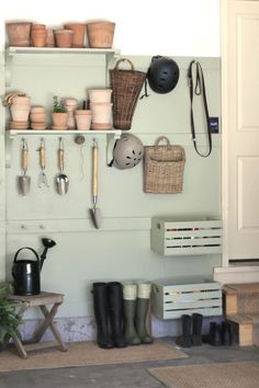 pots and gardening tools are hanging on the wall