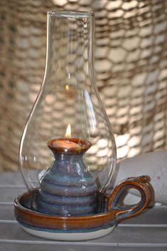 a glass vase with a candle inside on a table