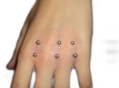 a woman's hand with five small dots on it