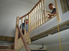 two men are working on an unfinished staircase