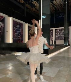 a man and woman are dancing on the dancefloor in front of posters that read ma