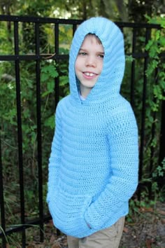 a young boy wearing a blue hooded sweater