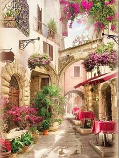 an alleyway with tables and chairs covered in pink flowered hanging baskets filled with flowers