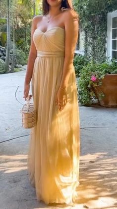 a woman in a yellow dress holding a basket and posing for the camera with her hand on her hip