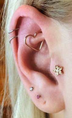 a close up of a person's ear with two piercings on top of it