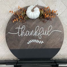 a wooden sign that says, thank you and has a white pumpkin on top of it