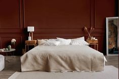 a bedroom with red walls and white furniture