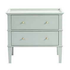 a white dresser with two drawers and gold knobs on the bottom, against a white background