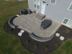 an aerial view of a patio and dining table in the backyard with landscaping around it