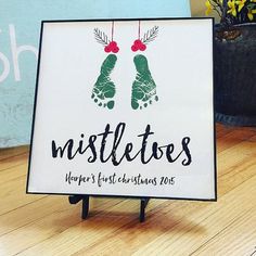 a sign that says mistletoes on it with two feet hanging from the top