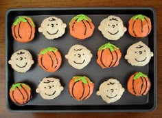 cupcakes decorated with faces and pumpkins on a tray