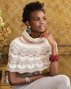 a woman sitting on a chair wearing a shawl