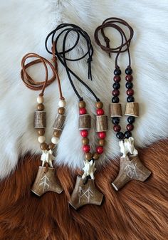 the necklaces are made from wood beads and other items on a cowhide rug