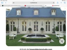 a house with two chairs and a fountain in the front yard