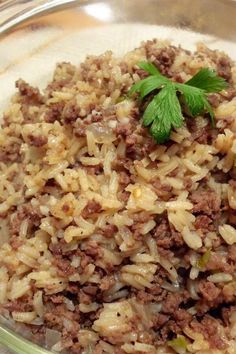 a glass bowl filled with rice and meat