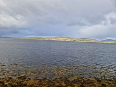 there is a large body of water with mountains in the background