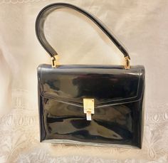 vintage koret! patent leather handbag, purse pocketbook, chic preppy stylish wear ! great handbag for the upcoming holiday ! gold-tone finish does show wear ! patent material show some wear, good clean interior condition, one slip interior pocket, double layer wide hand strap! Measurements Approximately: 6-3/4'' tall 8-1/2'' wide 5-7/8'' hand strap drop  Let me know if you have questions thanks for looking :) all sales are considered final buy vintage and save our environment Elegant Glossy Finish Shoulder Bag For Travel, Elegant Formal Shoulder Bag With Glossy Finish, Elegant Glossy Finish Shoulder Bag For Formal Use, Elegant Glossy Finish Shoulder Bag For Formal Occasions, Elegant Shoulder Bag With Glossy Finish For Office, Formal Glossy Satchel Bag, Elegant Glossy Shoulder Bag For Office, Elegant Glossy Finish Shoulder Bag For Office, Classic Formal Shoulder Bag With Glossy Finish