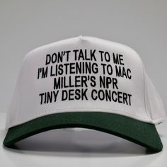 a white and green hat with black writing on the front that says don't talk to me i'm listening to mac miller's nr tiny desk concert