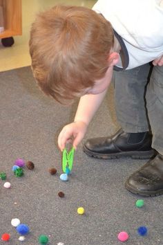 a young boy playing with toys on the floor