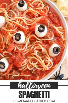 a white bowl filled with spaghetti topped with googly eyes and black olives for halloween