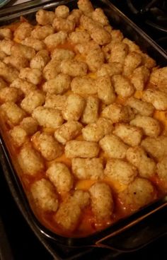 a pan filled with tater tots sitting on top of a stove