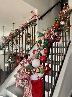 christmas decorations on the banisters and stairs in a home decorated with red, white and green ornaments