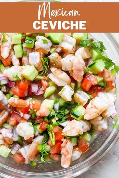 a glass bowl filled with shrimp, cucumber and tomato salad on top of a white table