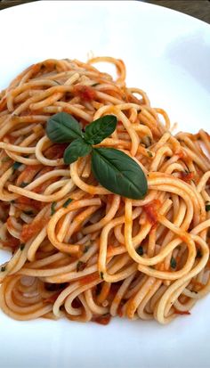 a white plate topped with pasta and sauce