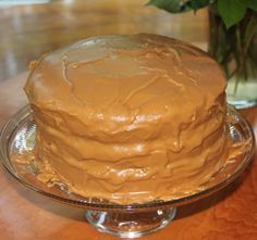 a frosted cake sitting on top of a glass plate