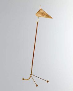 a floor lamp that is on top of a metal pole and has a wooden shade