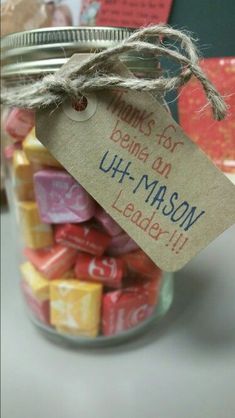 a jar filled with lots of colorful cubes next to a sign that says, hugs for being a uh - mason leader