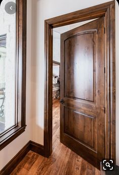 an empty room with a wooden door and large mirror on the wall next to it