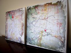 two maps are displayed on a table in front of a wall with white paint and brown paper