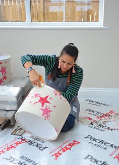 a woman sitting on the floor with some wrapping paper