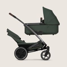 a green stroller with black wheels and an infant seat in the back, on a white background