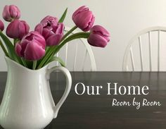 a vase filled with pink tulips on top of a wooden table