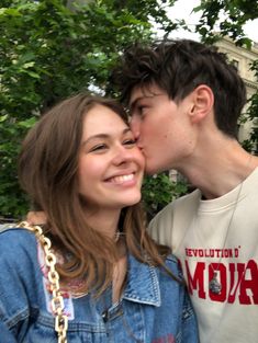 a young man and woman kissing each other