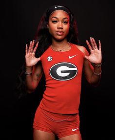 a woman with her hands in the air and wearing a red shirt that says georgia