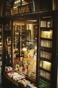 a book store with many books on display in the window and shelves full of books