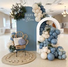 a baby shower is decorated with balloons and greenery in blue, white and grey colors