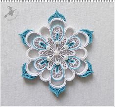 an origami snowflake is shown on a white surface with blue accents