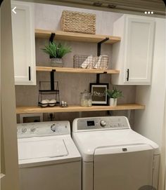 a washer and dryer in a room with open shelving on the wall