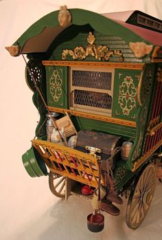 a toy horse drawn carriage with lots of items on it's back and sides