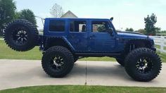 a blue jeep parked on top of a driveway