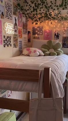 a bedroom with a bed and lots of pictures on the wall above it, along with a bag hanging from the ceiling