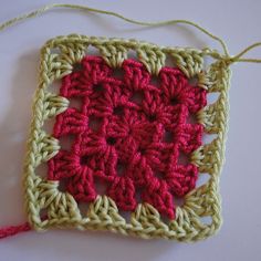 a crocheted square with red and green yarn