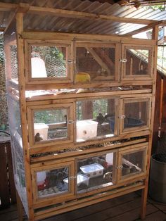 a caged in bird house with lots of windows on the top and bottom floor