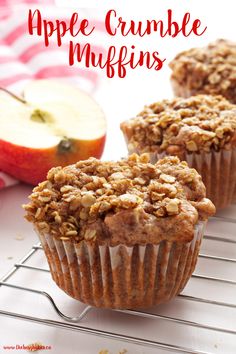 two muffins sitting on top of a cooling rack next to an apple slice