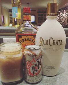 bottles of rumchata sit on a counter next to two jars with liquid in them