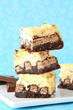 four pieces of cake sitting on top of a white plate next to some chocolate bars